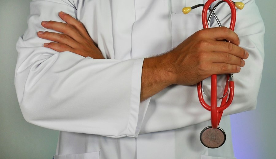 A clinician in a white coat holding a stethoscope