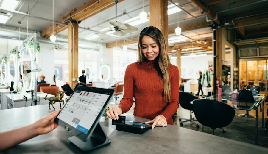 A shop assistant taking a payment at a point-of-sale screen
