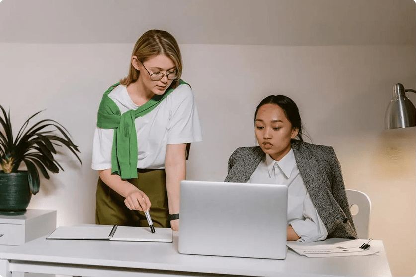 Two colleagues working through a plan at a laptop