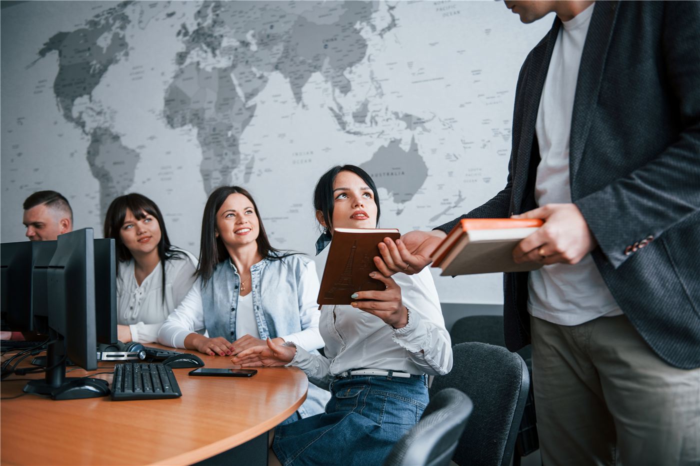 A team in a meeting with a world map on the wall behind them